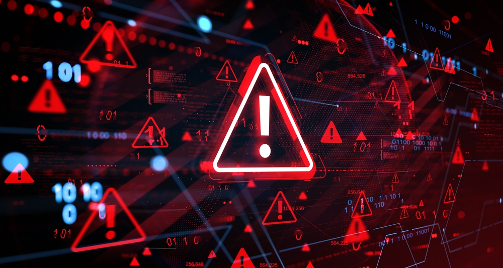 A glowing red warning triangle with an exclamation mark at the center of a dark digital field scattered with smaller alert triangles and binary code.